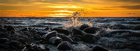 Waves Splashing At Stones On Beach During Sunset · Free Stock Photo