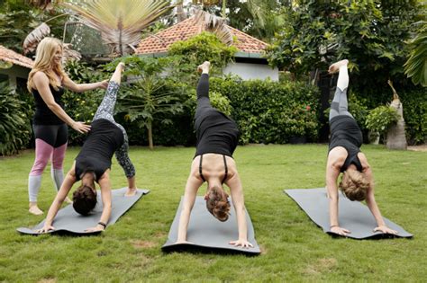 Grupo de mulheres fazendo yoga ao ar livre realizando pose de golfinho Foto Grátis