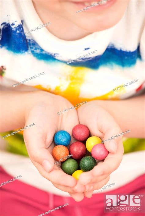 Little Girl 5 Years Holding Colorful Toy Marbles In Her Hands Stock