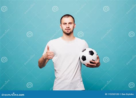 Portrait Of Young Man Holding A Soccer Ball Isolated On Green