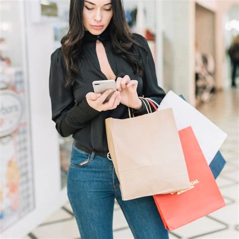 Free Photo Woman With Shopping Bags Browsing Smartphone