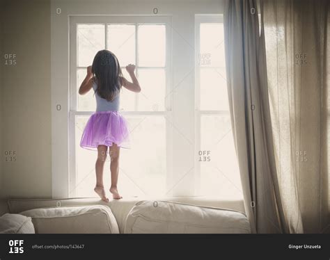 Little Girl Peeking Out The Window Stock Photo Offset