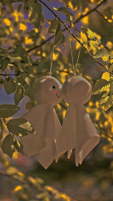 Two Teddy Bears Hanging From A Tree Branch