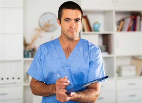 Male Nurse Filling Out Medical Form On Clipboard Stock Photo Image Of