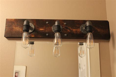 Creative bedroom lamp but perfect for so many spots in your home! DIY Industrial Bathroom Light Fixtures | Rustic bathroom light fixtures, Rustic bathroom ...