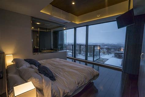 A Large Bed Sitting Next To A Tall Window In A Bedroom Under A Skylight