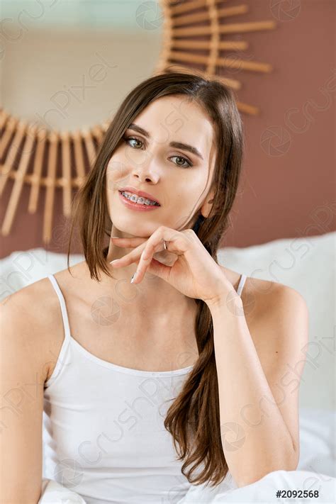 retrato de chica linda sentada en la cama sonriendo y foto de stock crushpixel