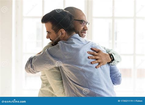 African And Caucasian Guys Hugging Glad To See Each Other Stock Image