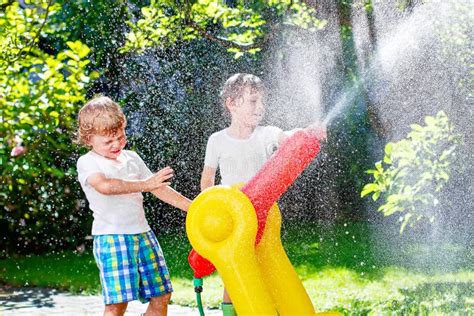 Two Little Kids Boys Playing With A Garden Hose Water Sprinkler Stock
