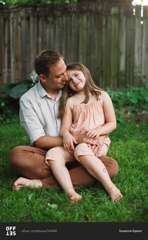 Daughter Sitting On Fathers Lap In Backyard Stock Photo Offset