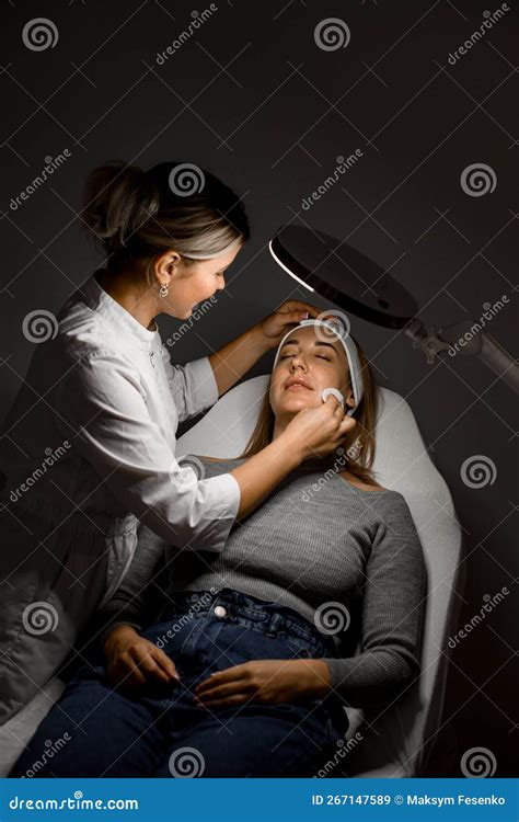 Professional Beautician Preparing Woman Client To The Cosmetological Procedure In Beauty Salon