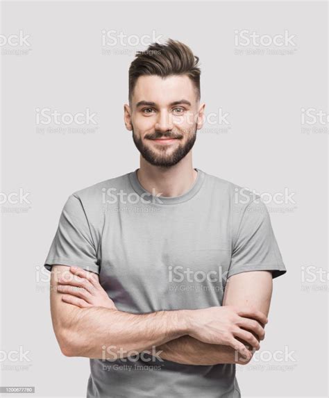 Portrait Of Handsome Smiling Young Man With Crossed Arms Stock Photo