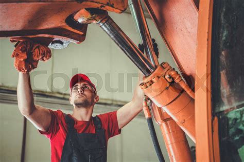 Heavy Equipment Mechanic Performing Excavator Maintenance Stock Image