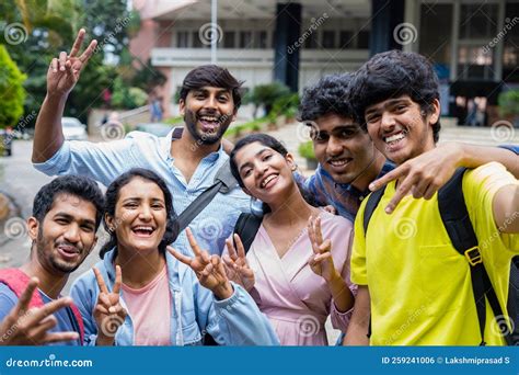 Group Of Smiling College Students Taking Selfie By Holding Camera At
