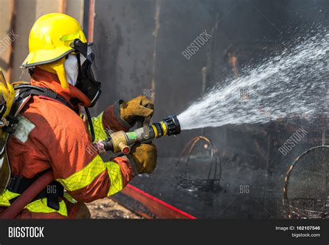 Firefighter Hold And Adjust Nozzle And Fire Hose Spraying High Pressure