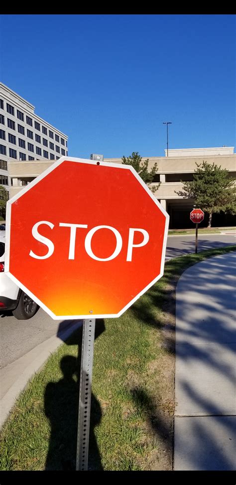 Two Stop Signs Close 5o Each Other With Different Fonts