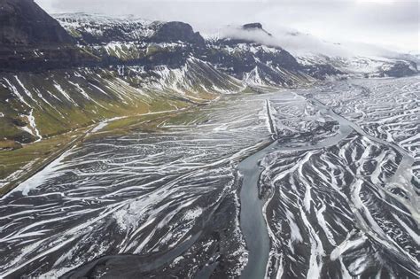 Aerial View Of A River Estuary Along The Mountain Range In Winter In