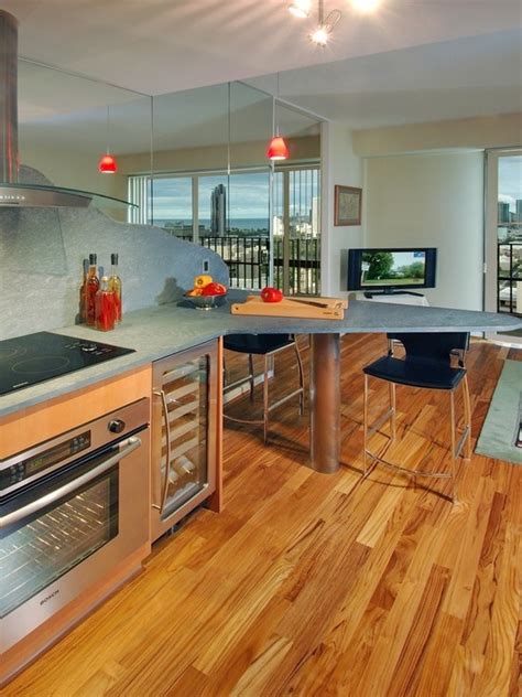 An Open Kitchen With Stainless Steel Appliances And Wood Flooring