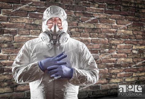Chinese Man Wearing Hazmat Suit Goggles And Gas Mask With Brick Wall