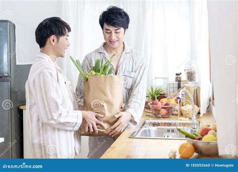Asian Gay Couple Homosexual Cooking Together In The Kitchen Prepare Fresh Vegetable Make Organic