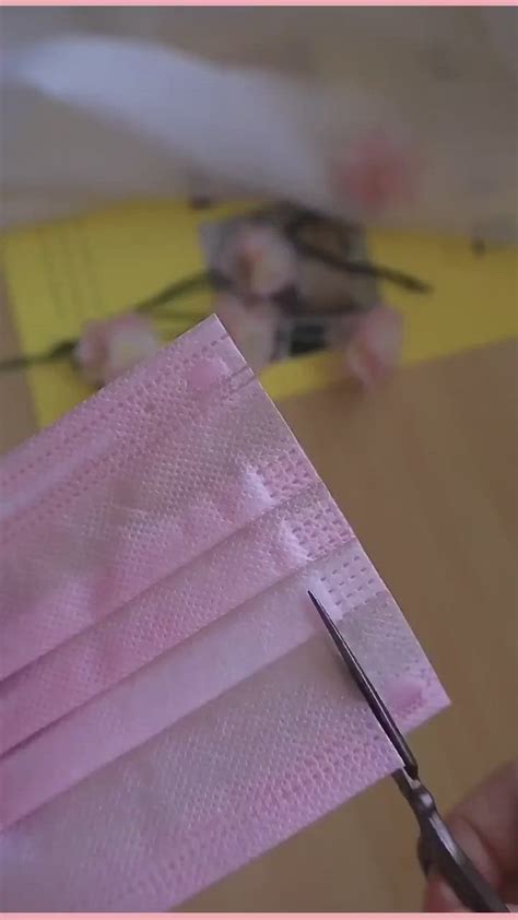 A Person Cutting Fabric With Scissors On Top Of A Piece Of Paper That