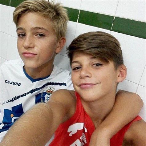 Two Young Boys Sitting Next To Each Other In Front Of A Tiled Wall And Floor