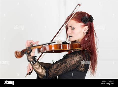 Young Woman Dressed In Gothic Style Playing Violin With Closed Eyes