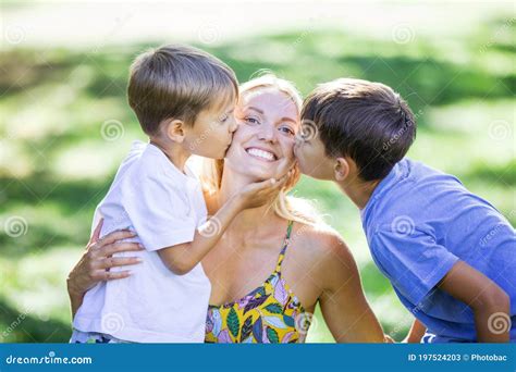 Two Young Boys Kissing Their Mother Outdoors Stock Image Image Of