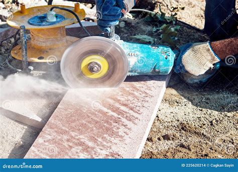 Hands Of A Pavement Construction Worker Using An Angle Grinder For