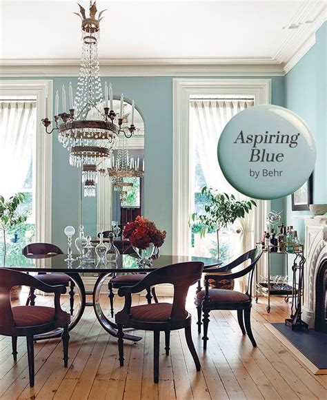 An Elegant Dining Room With Blue Walls And Wood Flooring Chandelier