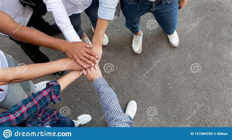 Multiracial Students Joining Hands Together In Cooperation Stock Image