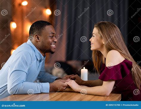 Romantic Date Loving Interracial Couple Sitting At Table In Restaurant Holding Hands Stock