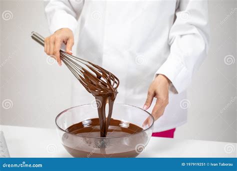 Closeup Female Chef Stirring Dark Melted Chocolate With Whisk White Background Stock Image