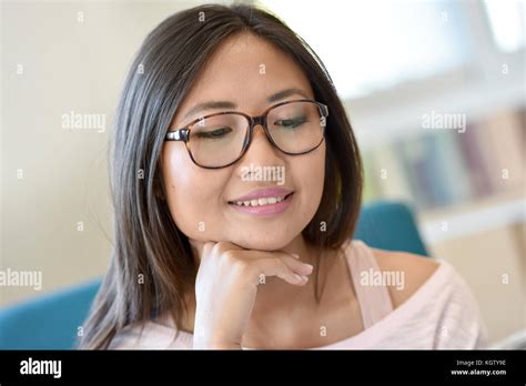 Portrait Of Young Asian Girl With Eyeglasses Reading Newspaper Stock