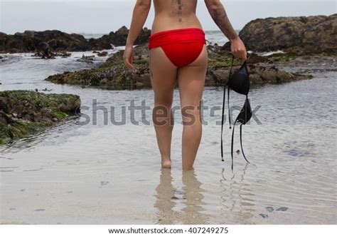 Back View Of Girl In Bikini Walking Into The Water On The Beach Topless
