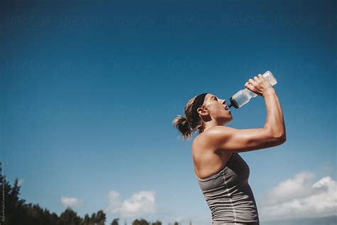 Active Sweaty Young Woman Drinking Water In Sunshine Del Colaborador