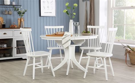 Extendable white round dining table and chairs. Hudson Round White Extending Dining Table with 4 Pendle ...