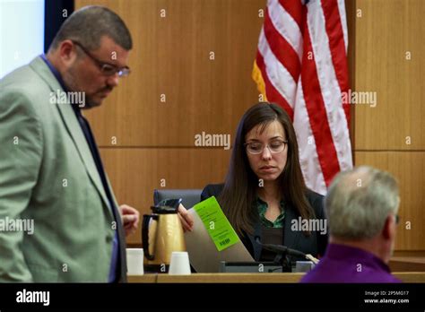 Defendant Jodi Arias Looks At Pictures Presented As Evidence Handed To