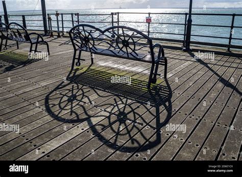 Bench Seat On The End Of Southend Pier Creating A Shadow On A Bright