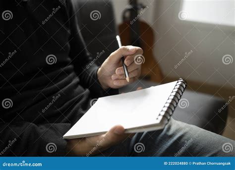 Homem Anotando No Notebook Sentado No Sofá Foto De Stock Imagem De