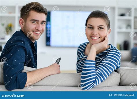 A Young Married Couple Enjoys Sitting In The Large Living Room Stock