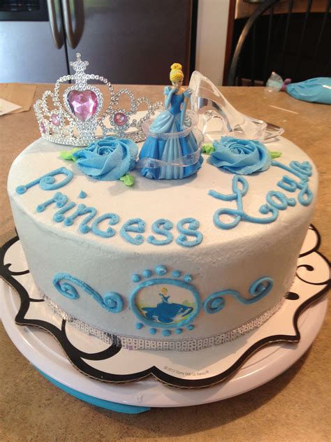 A Princess Cake With Blue Frosting And Decorations On The Top Is