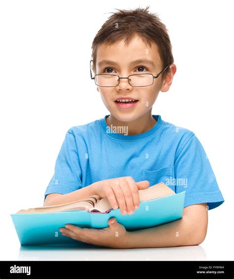 Cute Little Boy Is Reading A Book While Wearing Glasses Isolated Over