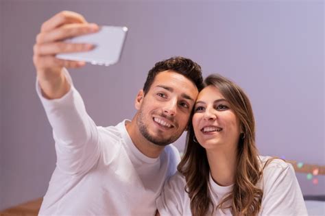Jeune Couple Au Lit Prenant Selfie Photo Gratuite
