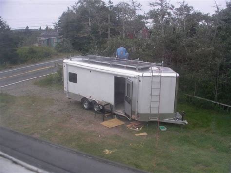 The Trailer Is Parked On The Side Of The Road With Its Door Open And It