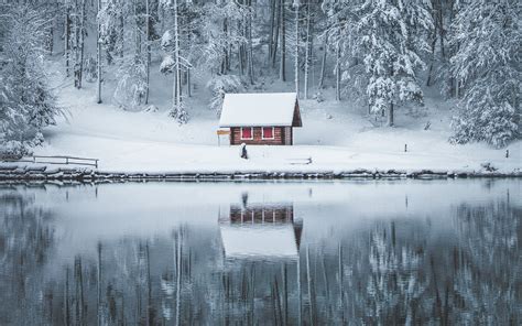 Small Cabin In The Woods Near A Lake After A Snowfall