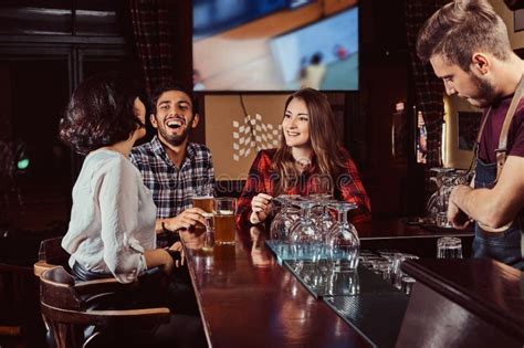 Group Of Happy Multiracial Friends Resting And Talking At Bar Or Pub