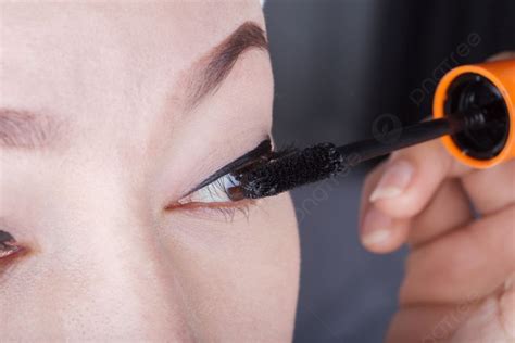 Close Up Woman Applying Mascara On Her Eyelashes Photo Background And