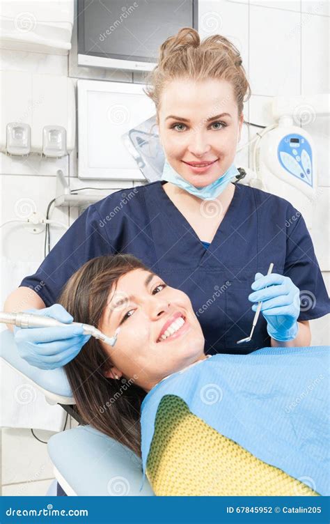 Beautiful Dentist Is Treating Teeth Of The Patient Stock Photo Image