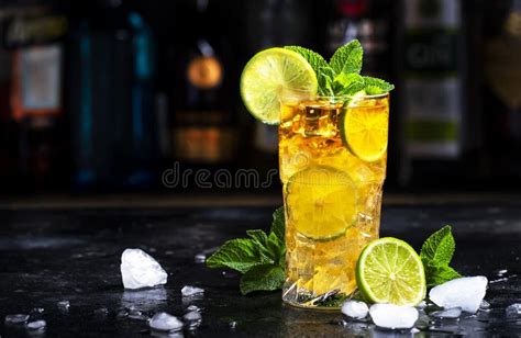 Dark And Stormy Cocktail Drink With Dark Rum Ginger Ale Lime And Ice With Bottles Black Bar